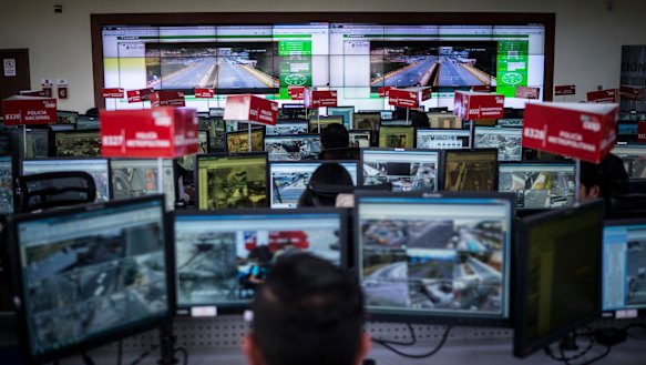 A control room of camera feeds and workers, part of Ecuador's Emergency Response System.