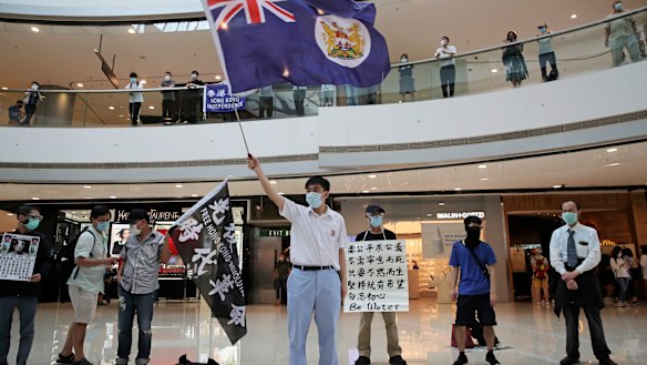 Protesters wave a Hong Kong colonial flag in a shopping mall during a protest against China's national security legislation for the city, in Hong Kong in May.
