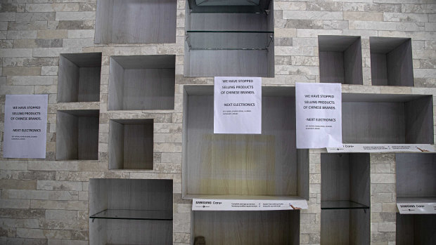 Notices hang near empty shelves after the removal of Chinese-made products in an electronic shop in Gauhati, India. 