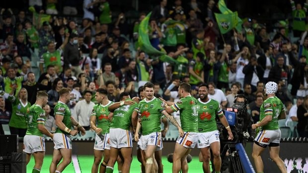 Canberra players celebrate last week's win against the Sydney Roosters in front of thousands of travelling fans, who won't be allowed entry into Queensland this weekend.