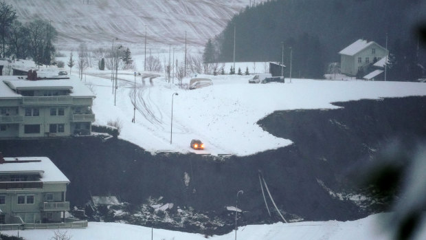 A car is stopped at the edge of a cliff after a landslide occurred in a residential area in Ask, near Oslo.