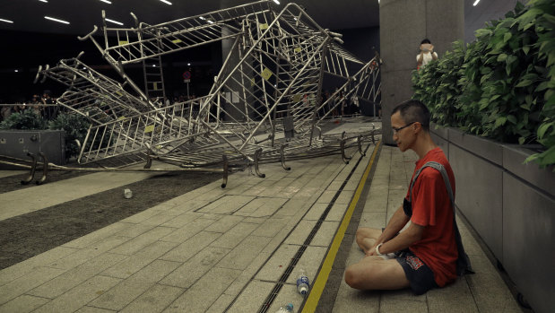 A protester sits near barriers after clashes during the rally against Hong Kong's extradition law.