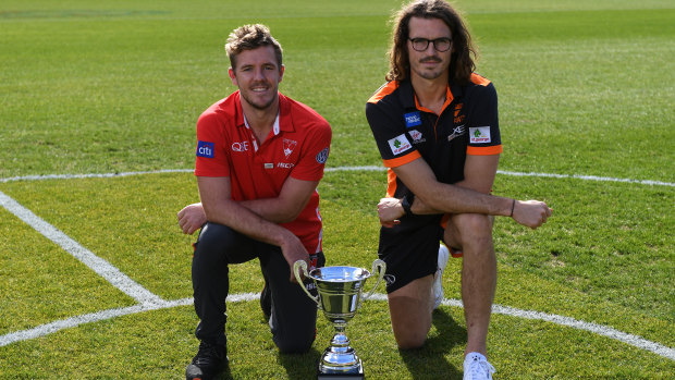 Swans co-captain and Giants co-captain Phil Davis pose with the Sydney AFL derby trophy.