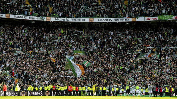Celtic players celebrate with supporters at Parkhead after an Old Firm victory. 