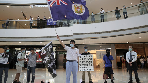 Protesters wave a Hong Kong colonial flag in a shopping mall during a protest against China's national security legislation for the city, in Hong Kong in May.