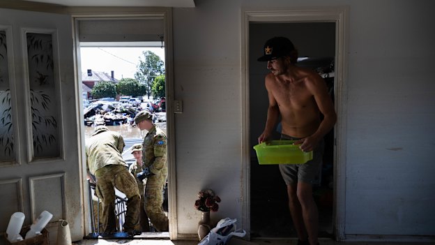 Members of the ADF join up with community volunteers to clear the house of an elderly couple.