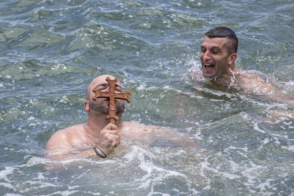 'I caught the cross first': Mikes Legkos (left) grabbed the cross before the official pack at the Greek Orthodox Blessing of the Waters swim at Princes Pier.