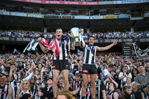 Cox (left) celebrates with the 2023 AFL premiership trophy.