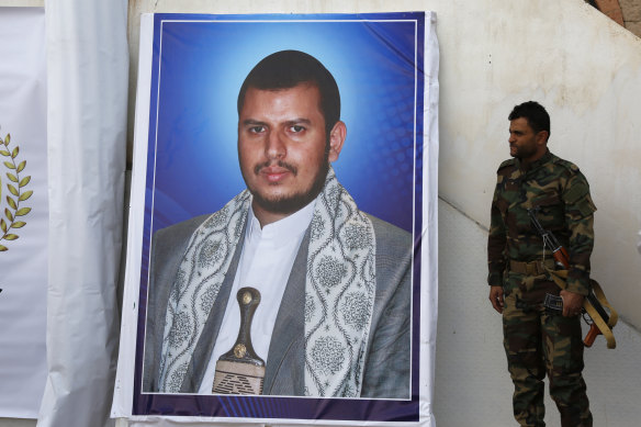 A soldier stands next to a banner with a picture of the leader of the Houthi movement, Abdul-Malik al-Houthi, in Sana’a, Yemen, in 2020. 