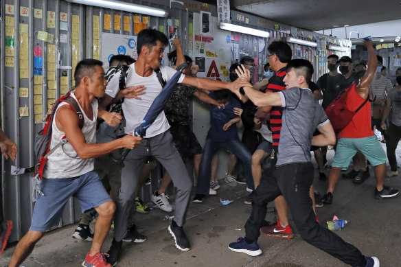 A group of pro-police supporters fight with an anti-government protester, right, outside the Amoy Plaza in the Kowloon Bay district in Hong Kong, Saturday, September 14, 2019. 