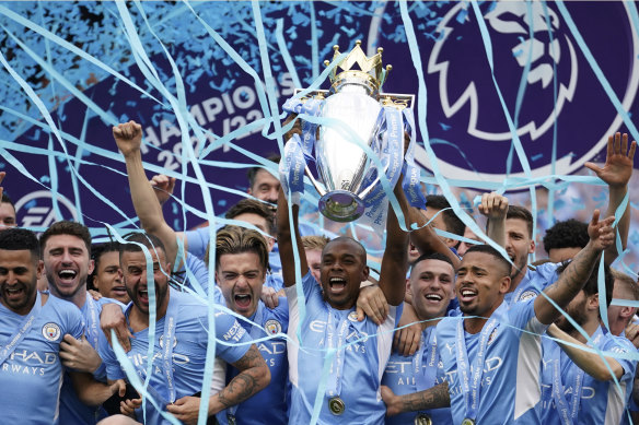 Manchester City players celebrate with the 2022 Premier League trophy.