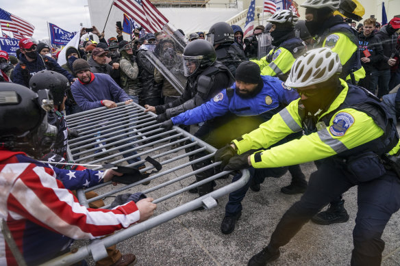 Rioters try to break through a police barrier at the Capitol in Washington.  