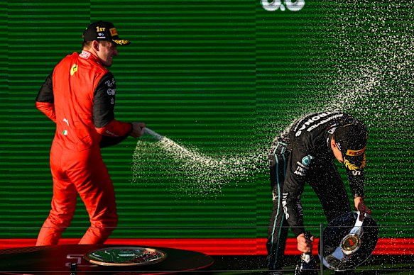 Charles Leclerc sprays George Russell, right, on the podium. 
