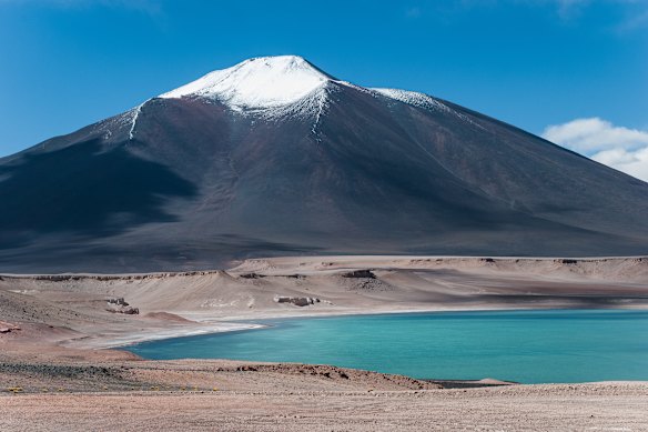 The emerald waters of Laguna Verde (Green Lagoon), resting at 4,200 meters above sea level in Chile, beneath Atacama’s Ojos de Salado.