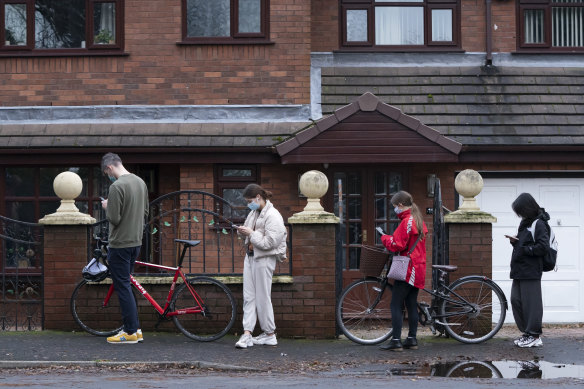 People queue outside a vaccination centre in Manchester, England.