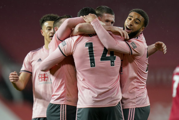 Oliver Burke (centre) is swamped by his Sheffield United teammates after scoring the winner.
