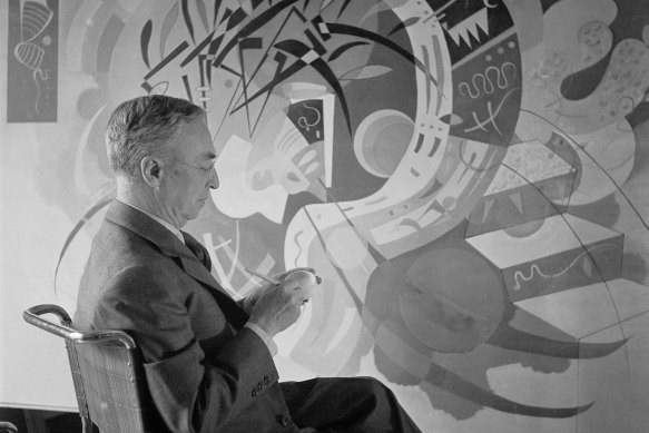 Vasily Kandinsky with his work, Dominant Curve in Paris, 1936.