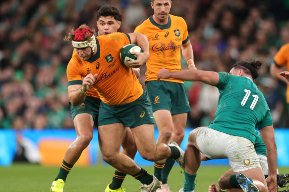 Fraser McReight runs with the ball whilst under pressure from James Lowe.
