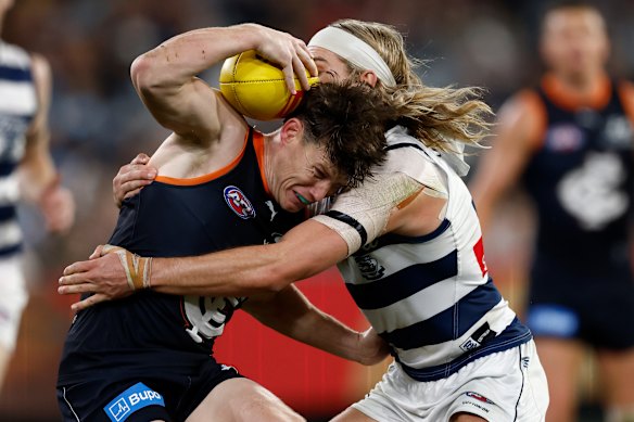 Sam Walsh tries to burst through a Bailey Smith tackle.