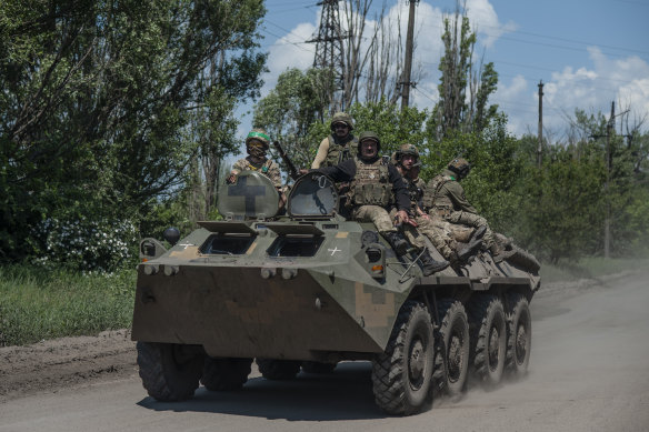 Ukrainian soldiers board an armored personnel carrier on the front line near Bakhmut.