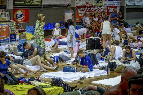 Evacuees sit inside a stadium following their evacuation during a forest fire on the island of Rhodes, Greece on Sunday.