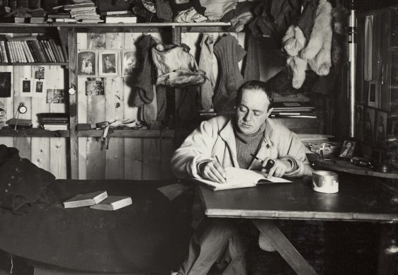 Captain Robert Falcon Scott writing in  the expedition hut.