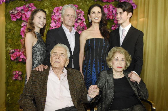 Kirk Douglas and his wife Anne in front of their son Michael, his wife Catherine Zeta-Jones and their children, Carys and Dylan, at Kirk's 100th birthday party at the Beverly Hills Hotel in 2016.