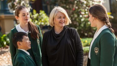 Dr Maree Herrett, principal of Santa Sabina College, with students wearing the green uniforms in 2016.