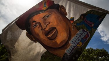 A supporter waves a flag displaying the image of late Venezuelan president Hugo Chavez during a pro-government rally against US President Donald Trump in Caracas, Venezuela, last August.