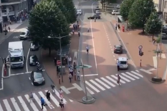 People run in the street after hearing gunshots in Liege, Belgium.