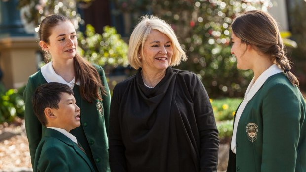 Dr Maree Herrett, principal of Santa Sabina College, with students wearing the green uniforms in 2016.