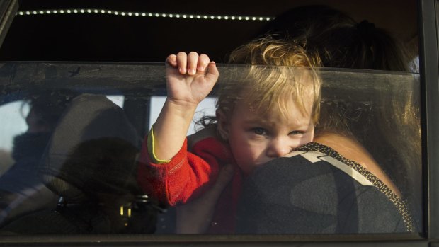 A child is pictured unrestrained in a car.