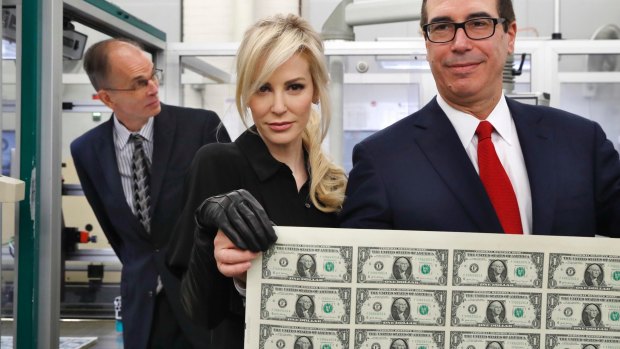 Louise Linton, pictured with husband and Treasury Secretary Steven Mnuchin, was mercilessly mocked for this villainous photo of her holding new $1 bills while wearing leather gloves. 