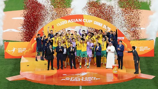 The Young Socceroos lift the Asian Cup trophy.