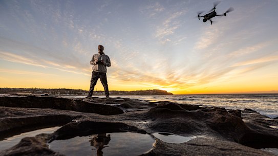 Jason Iggledon flying his drone on the rocks at the southern end of Bondi Beach.