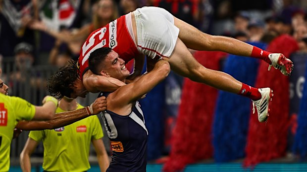 Patrick Voss of the Dockers picks up and carries Ed Langdon of the Demons on his shoulder.