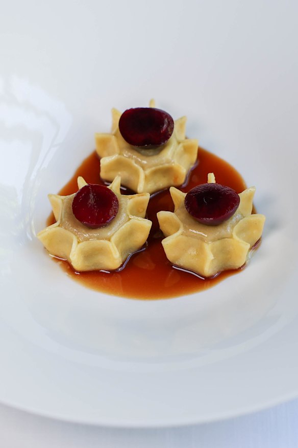 Sun-shaped duck ravioli, each topped with a pickled cherry.