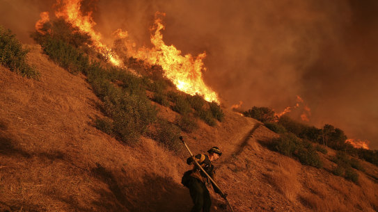 A firefighter battles the Palisades Fire in Mandeville Canyon Saturday, Jan. 11, 2025, in Los Angeles. (AP Photo/Jae C. Hong)