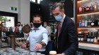 NSW Premier Dominic Perrottet, right, seen with Deputy Premier Paul Toole, pours a beer at Watson’s Pub in Moore Park on Monday morning.