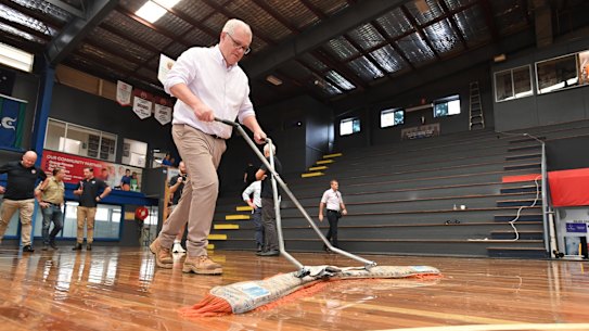 Prime Minister Scott Morrison dries a flood-damaged court in Brisbane in early March. 