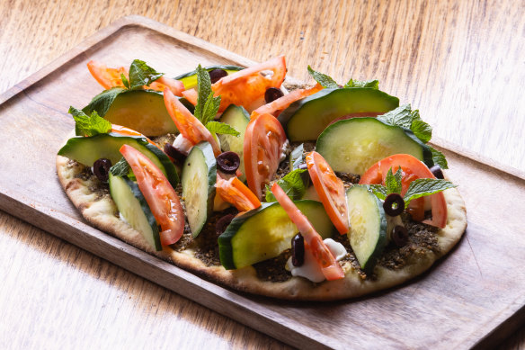 Zaatar manakish with labne, tomato, cucumber and olives.
