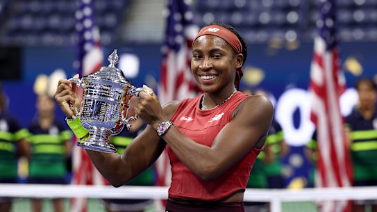Coco Gauff celebrates with the US Open trophy.