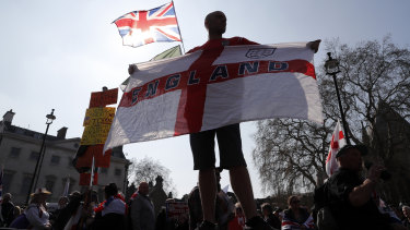 A Brexit supporter holds an England flag at Parliament Square in Westminster, London. 