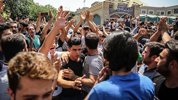 A group of protesters chant slogans at the main gate of the Old Grand Bazaar, in Tehran, Iran in 2018.