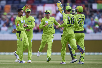 Tanveer Sangha (left) of the Thunder celebrates with team mates after taking the wicket of Andre Fletcher of the Stars during the Big Bash League match between the Melbourne Stars and Sydney Thunder at Manuka Oval, on December 12, 2020, in Canberra.