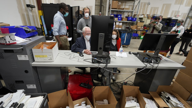 Democratic and Republican representatives review absentee ballots at the Fulton County election center. 