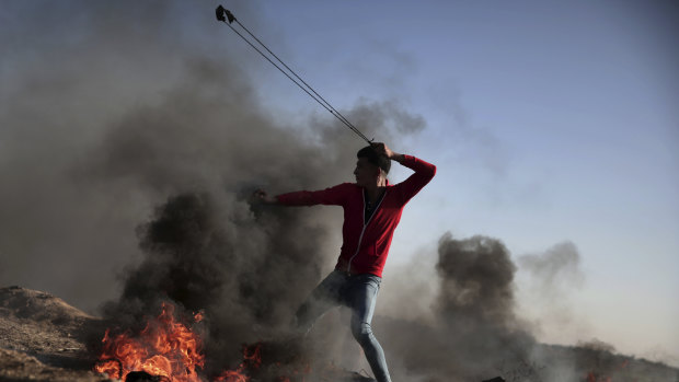 A Palestinian protester hurls stones toward Israeli soldiers during a protest in eastern Gaza City on Saturday.
