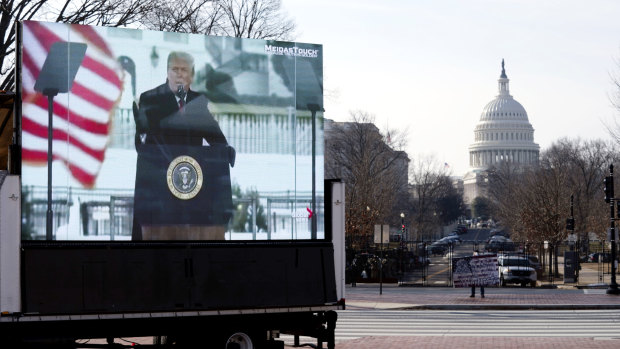 A photo of former President Donald Trump appears on a billboard truck parked near of the US Capitol during the impeachment trial.