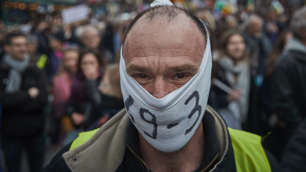A protester wears a "49.3" face wrap during demonstrations in response to France enacting article 49.3 of the constitution to force through the pension reform bill.