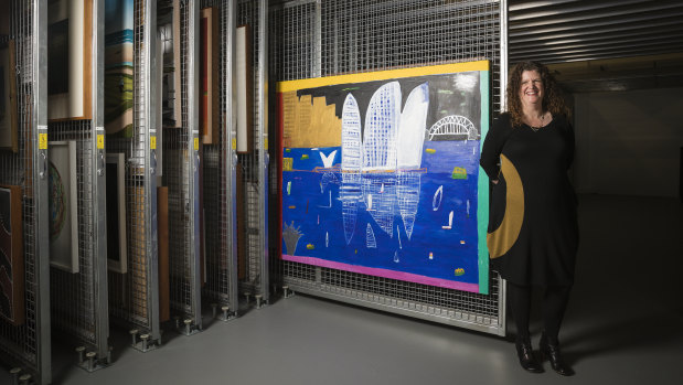 Director of the Parliament House art collection Justine van Mourik shows off a Ken Done painting in the art storeroom.